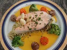 Pochierte Lachsschnitte auf Spaghetti, Alpenbuttersauce, und Gemüse